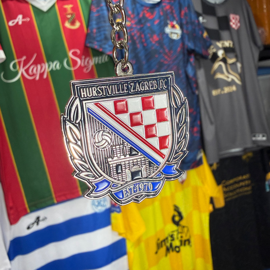 Metallic badge with crest design hanging among sports jerseys